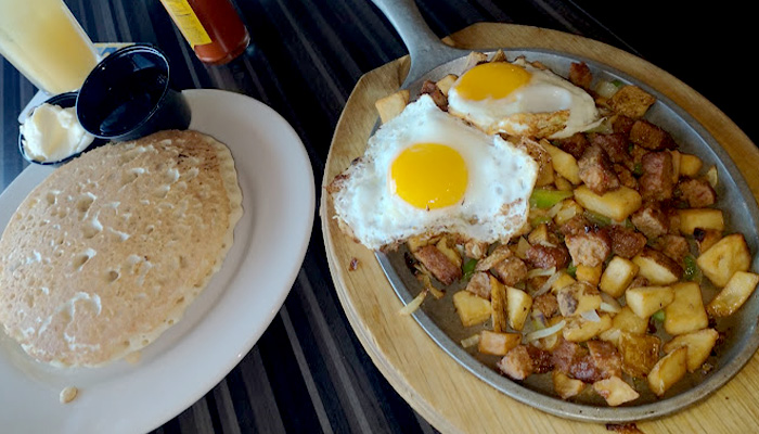 Two eggs sunny side up with potatoes and pancakes served for breakfast at Toley's on the Creek