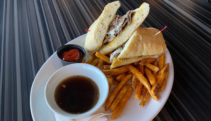 French dip roast beef sandwich and sweet potato fries at Toley's on the Creek restaurant and bar in Centennial, CO